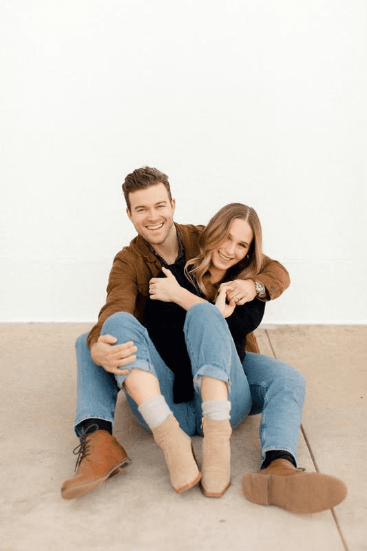 David and Mikayla Blease sitting together against a white wall
